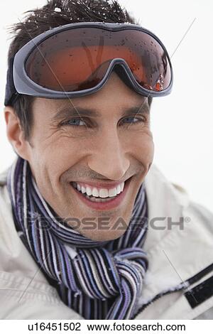 Man wearing ski goggles smiling portrait close up View Large Photo Image Stock Image - Man wearing ski goggles smiling portrait close up. Fotosearch