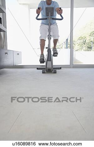 Mature man on exercise bike pedalling low section View Large Photo Image Stock Photograph - Mature man on exercise bike pedalling low section. Fotosearch