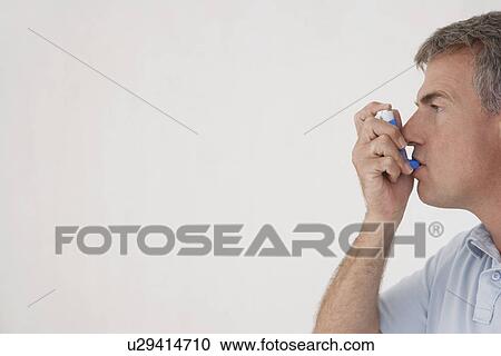 Stock Image - Mature man using inhaler profile. Fotosearch