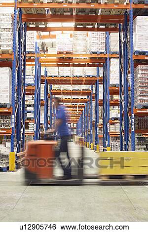 Mid-adult Man Driving Pallet Jack Through Warehouse side view View Large Photo Image Stock Photograph - Mid-adult Man Driving Pallet Jack Through Warehouse side view. Fotosearch