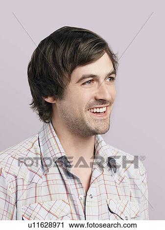Mid adult man looking away and smiling View Large Photo Image Stock Image - Mid adult man looking away and smiling. Fotosearch