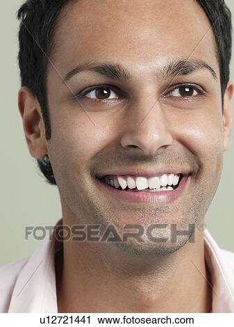 Stock Image - Mid adult man looking away and smiling close-up. Fotosearch
