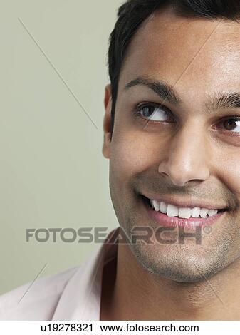 Stock Image - Mid adult man looking away and smiling close-up. Fotosearch