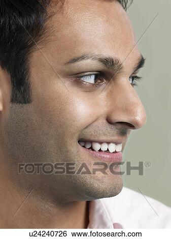 Stock Photograph - Mid adult man looking away and smiling close-up. Fotosearch