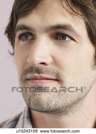 Stock Photo - Mid adult man looking away close-up of face. Fotosearch