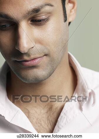 Picture - Mid adult man looking down close-up. Fotosearch
