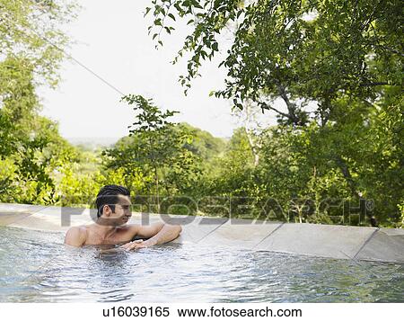 Mid adult man sitting in pool looking at view View Large Photo Image Stock Photography - Mid adult man sitting in pool looking at view. Fotosearch