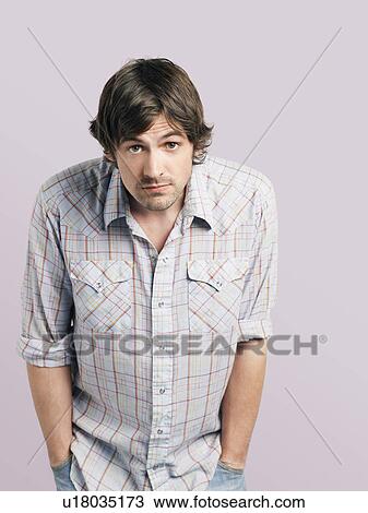 Mid adult man standing with hands in pockets View Large Photo Image Stock Image - Mid adult man standing with hands in pockets. Fotosearch