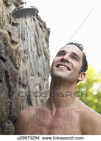 Picture - Mid adult man taking shower smiling outdoors. Fotosearch