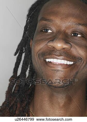 Stock Photo - Mid adult man with dreadlocks looking up close-up. Fotosearch