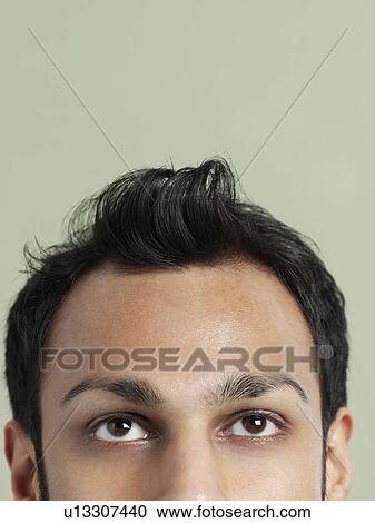 Stock Image - Mid adult man with messy hair close-up of head high section. Fotosearch