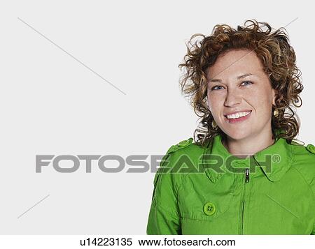 Stock Photography - Mid adult woman in green jacket smiling. Fotosearch
