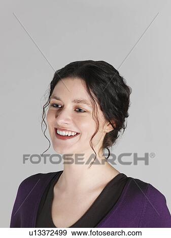 Stock Photo - Mid adult woman looking away and smiling. Fotosearch