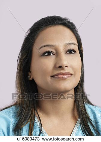 Stock Image - Mid-adult woman looking away and smiling close-up. Fotosearch