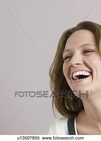 Stock Photography - Mid-adult woman looking away and laughing close-up. Fotosearch