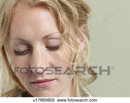Stock Photography - Mid adult woman looking down close-up. Fotosearch