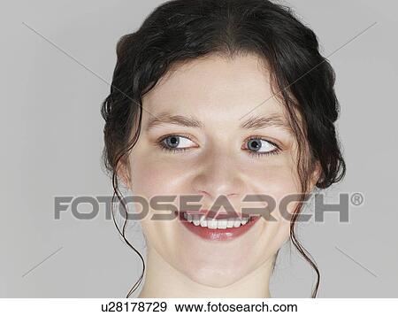Mid adult woman looking to side and smiling close-up View Large Photo Image Stock Photo - Mid adult woman looking to side and smiling close-up. Fotosearch