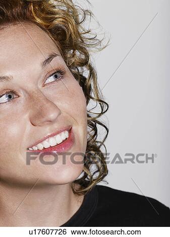 Mid adult woman looking up and smiling close-up View Large Photo Image Stock Photograph - Mid adult woman looking up and smiling close-up. Fotosearch