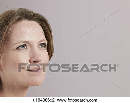 Mid-adult woman looking up close-up View Large Photo Image Stock Image - Mid-adult woman looking up close-up. Fotosearch