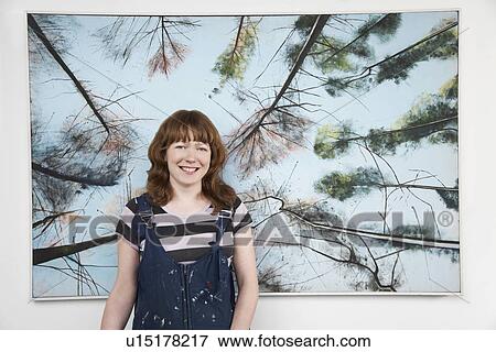 Mid adult woman standing in front of large painting View Large Photo Image Stock Photo - Mid adult woman standing in front of large painting. Fotosearch