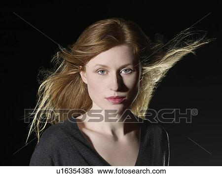 Stock Image - Mid adult woman with windswept hair. Fotosearch