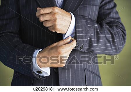 Middle-aged businessman in full suit buttoning buttons on shirt mid section View Large Photo Image Stock Image - Middle-aged businessman in full suit buttoning buttons on shirt mid section. Fotosearch