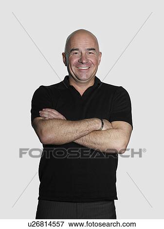 Stock Photo - Middle-aged man standing with arms crossed. Fotosearch