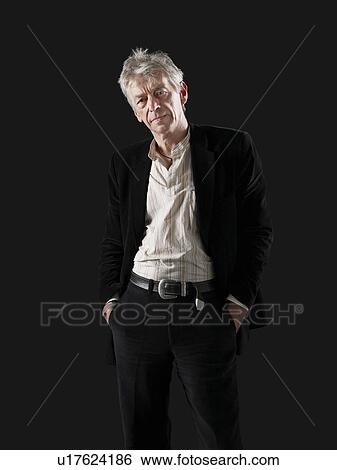 Stock Photograph - Middle-aged man standing with hands in pockets. Fotosearch