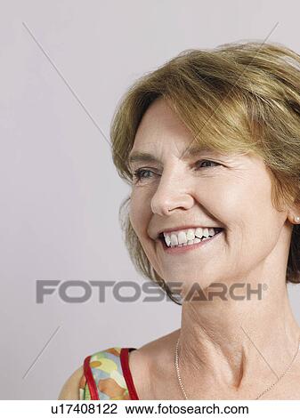 Stock Image - Middle-aged woman looking away and laughing close-up. Fotosearch