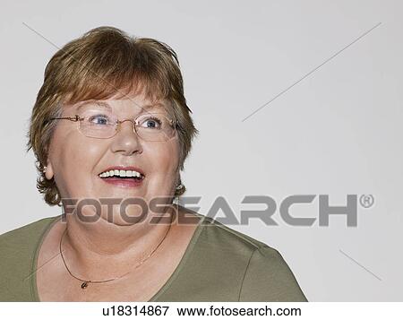 Middle-aged woman looking away and smiling close-up View Large Photo Image Stock Photo - Middle-aged woman looking away and smiling close-up. Fotosearch