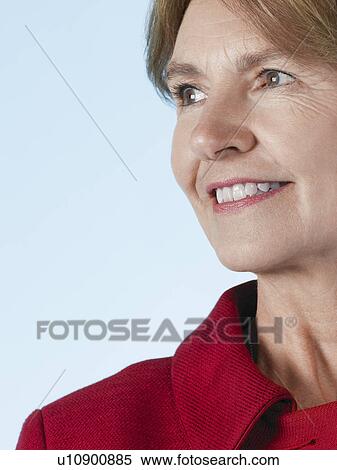 Stock Photography - Middle-aged woman looking away and smiling close-up. Fotosearch