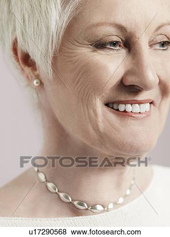 Middle-aged woman looking to side and smiling close-up (cropped) View Large Photo Image Stock Photo - Middle-aged woman looking to side and smiling close-up (cropped). Fotosearch