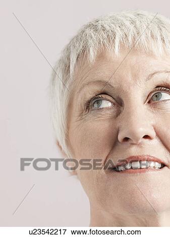 Stock Photo - Middle-aged woman looking up and smiling close-up. Fotosearch
