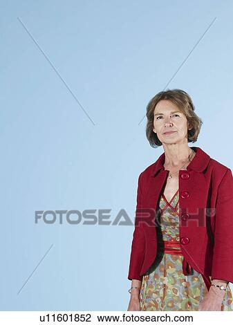 Stock Image - Middle-aged woman on blue background. Fotosearch