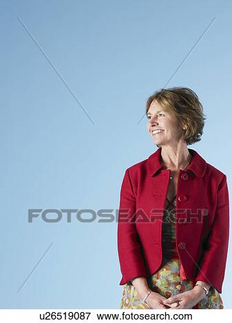 Middle-aged woman on blue background looking to side and smiling View Large Photo Image Stock Photo - Middle-aged woman on blue background looking to side and smiling. Fotosearch