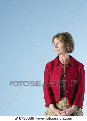 Middle-aged woman on blue background looking to side View Large Photo Image Stock Photograph - Middle-aged woman on blue background looking to side. Fotosearch