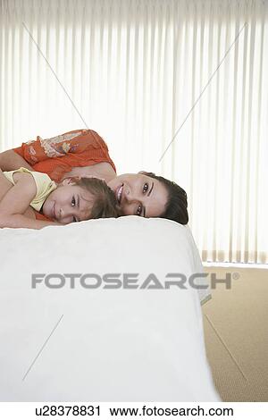 Mother and daughter (5-6) relaxing on bed View Large Photo Image Stock Image - Mother and daughter (5-6) relaxing on bed. Fotosearch