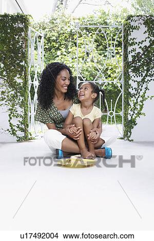 Mother and daughter (5-6 years) sitting on verandah floor View Large Photo Image Picture - Mother and daughter (5-6 years) sitting on verandah floor. Fotosearch