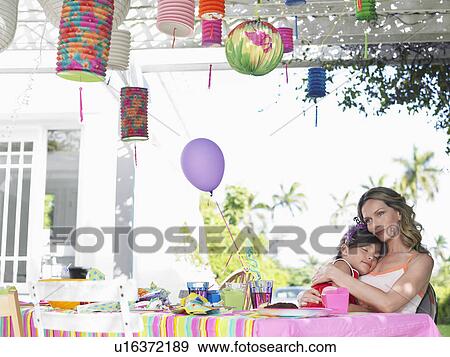 Stock Photo - Mother and daughter (7-9) at birthday table girl sleeping. Fotosearch