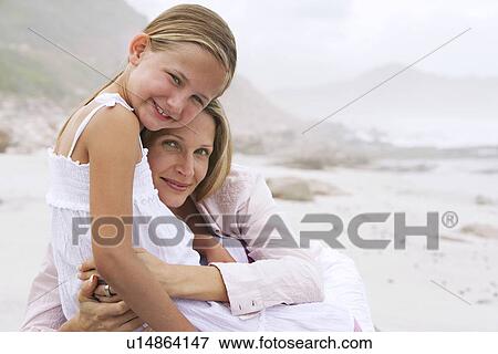 Mother and daughter (7-9) hugging on beach portrait View Large Photo Image Stock Photo - Mother and daughter (7-9) hugging on beach portrait. Fotosearch