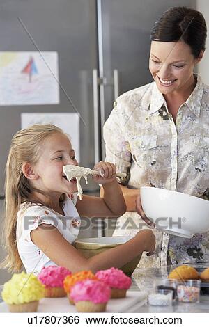 Stock Photograph - Mother and Daughter Making Cupcakes in kitchen. Fotosearch