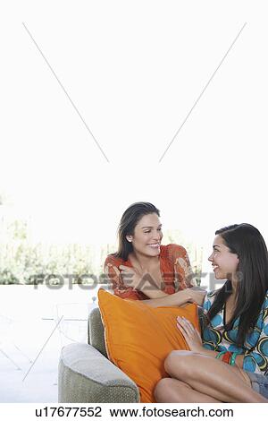 Stock Image - Mother and teenage girl (16-18) sitting on sofa. Fotosearch