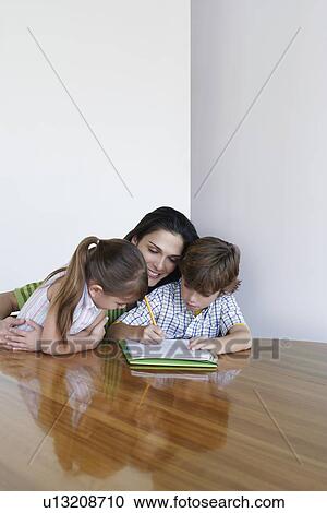Mother assisting son (7-9) and daughter (5-6) doing homework View Large Photo Image Stock Image - Mother assisting son (7-9) and daughter (5-6) doing homework. Fotosearch