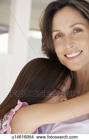 Picture - Mother cuddling sleeping daughter head and shoulders. Fotosearch
