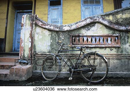 Stock Photograph - Old fashioned bicycle left by crumbling wall. Fotosearch