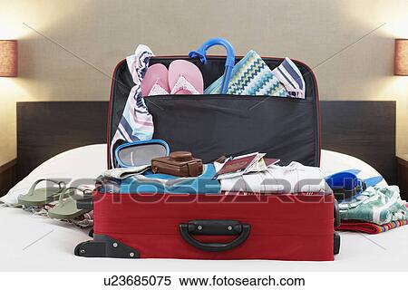 Stock Photography - Open suitcase on bed. Fotosearch