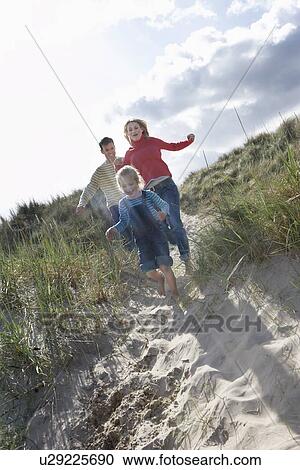 Parents and daughter (5-6) running through sand dunes View Large Photo Image Stock Image - Parents and daughter (5-6) running through sand dunes. Fotosearch