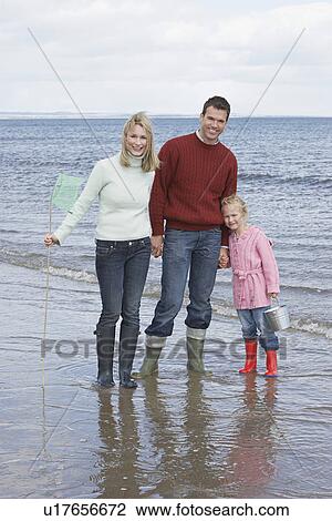 Parents with daughter (5-6) at ocean portrait View Large Photo Image Stock Image - Parents with daughter (5-6) at ocean portrait. Fotosearch