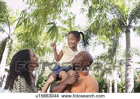 Picture - Parents with daughter (5-6 years) in tropical forest low angle view. Fotosearch