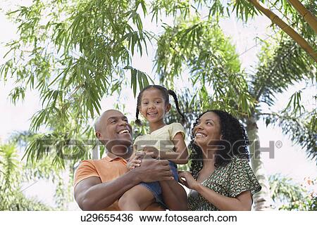 Parents with daughter (5-6 years) in tropical forest low angle view portrait View Large Photo Image Stock Photograph - Parents with daughter (5-6 years) in tropical forest low angle view portrait. Fotosearch